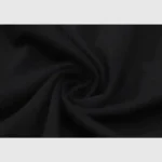 Close-up of a dark fabric with a swirl pattern, reminiscent of the Hellstar Path To Paradise T-Shirt, highlighting its texture and soft folds. The fabric seems smooth and slightly matte, enhancing the depth of its dark color.